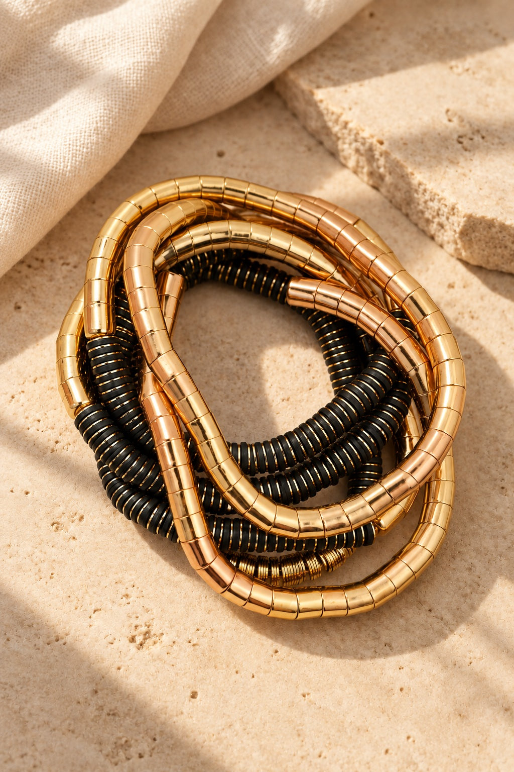 Golden Noir Coil Bracelet Stack on stone