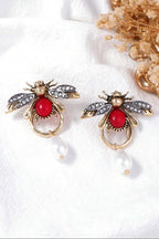 Ruby Bee Pearl Drop Earrings pair flat lay