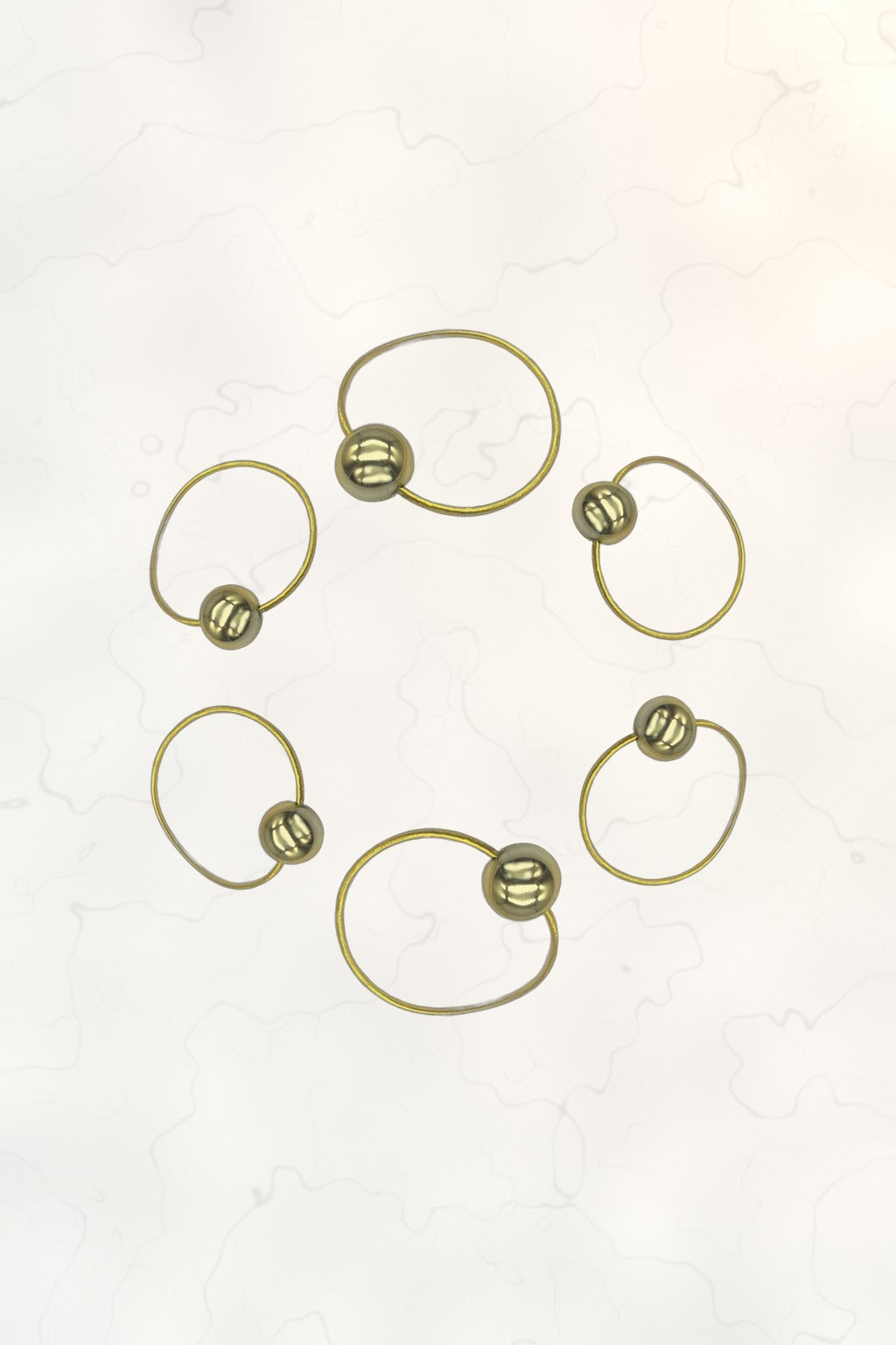 Bubble Ponytail Set of 6 – 6 gold ball hair ties arranged in a circle on marble