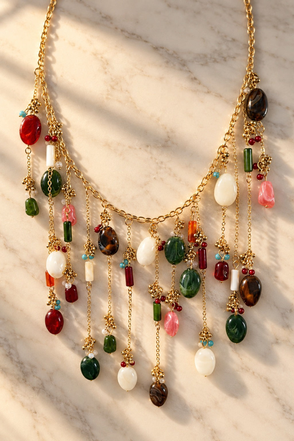 Gemdrop Waterfall Necklace – multicolour bead waterfall necklace on white marble in warm golden-hour sunlight