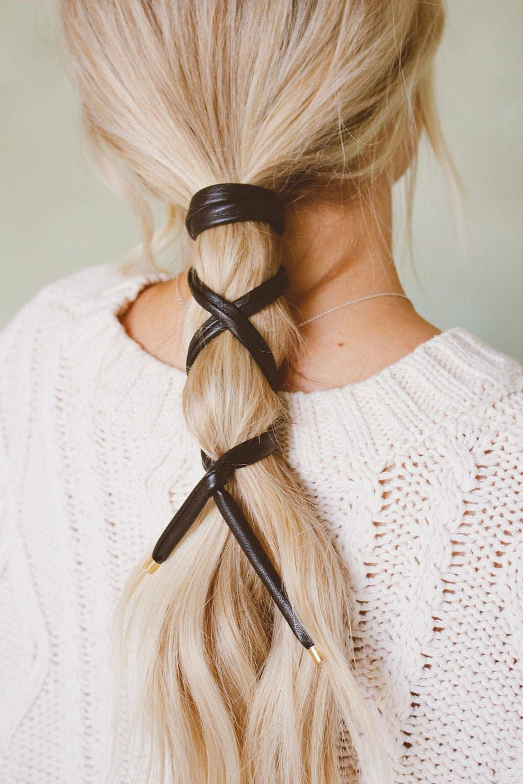 Black leather wrap ponytail tie worn criss-cross on a braid