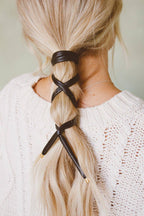 Black leather wrap ponytail tie worn criss-cross on a braid
