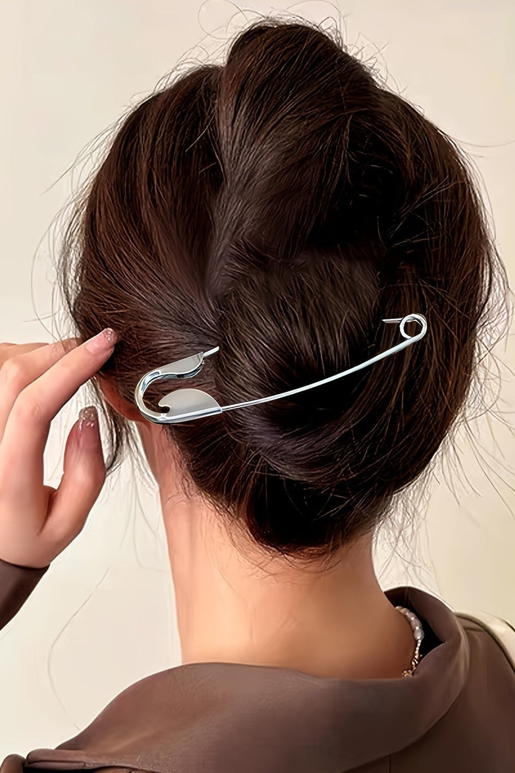 Silver safety pin hair pin worn in a low bun