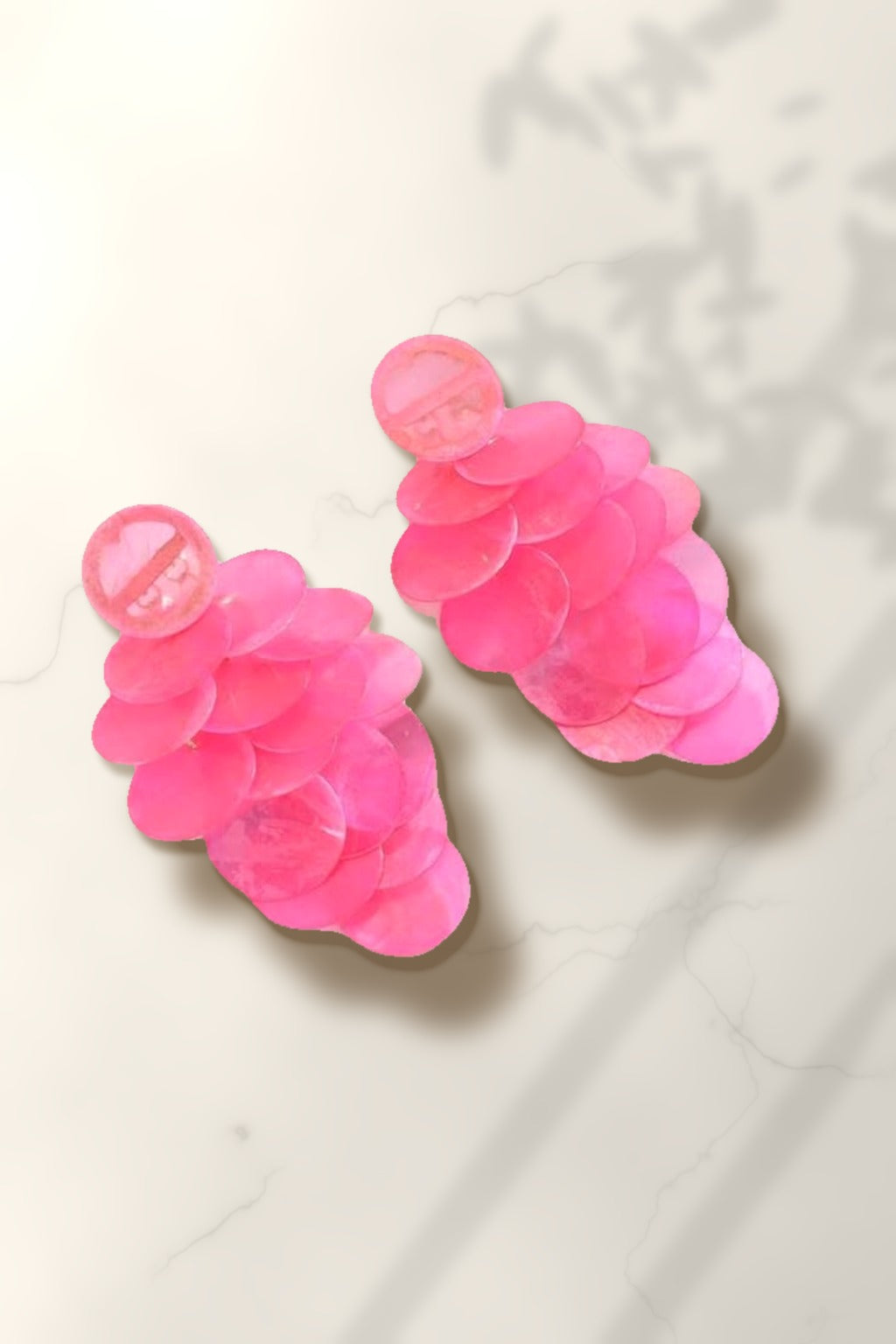 Pink Shell Cascade Earrings – pink capiz shell disc drop earrings on white marble in warm golden-hour sunlight