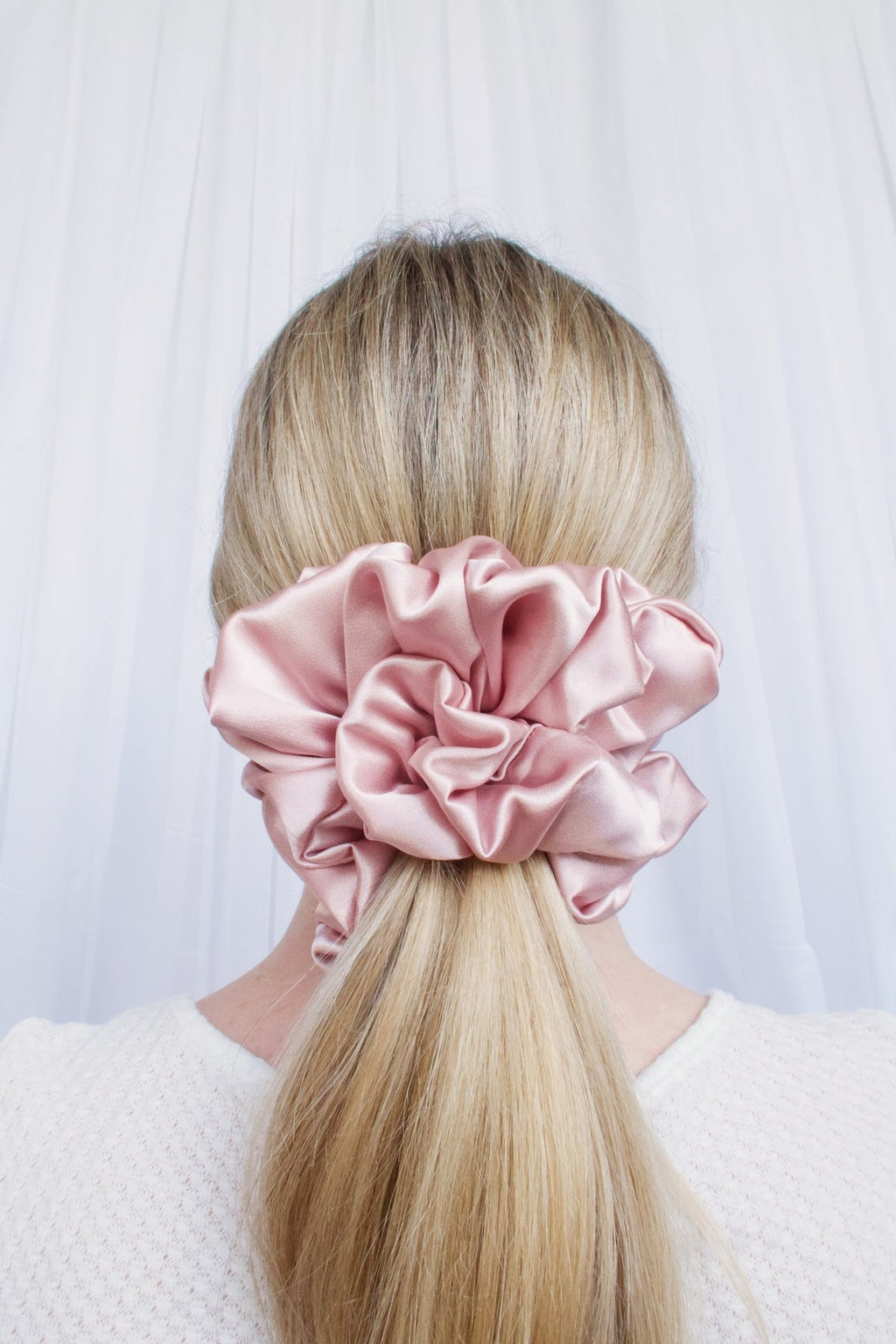 Big fluffy pink satin scrunchie worn on a ponytail