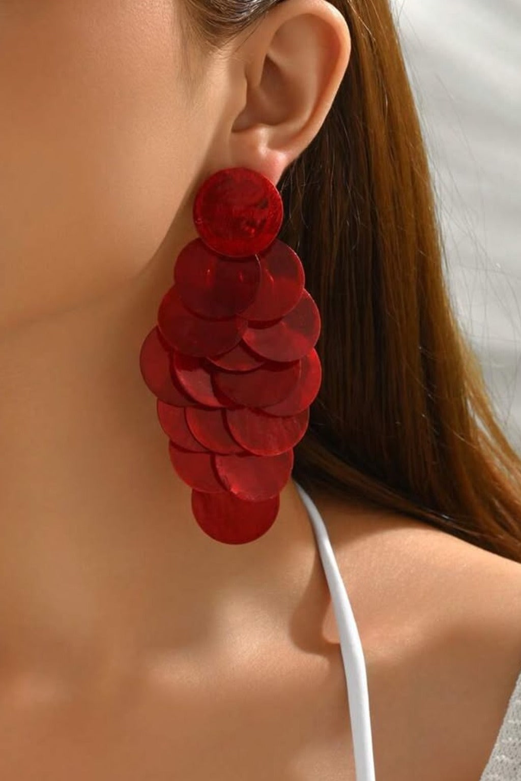 Red Shell Cascade Earrings worn on the ear – red shell disc cascade drop