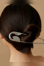 Oversized silver safety pin hair pin worn in a low bun