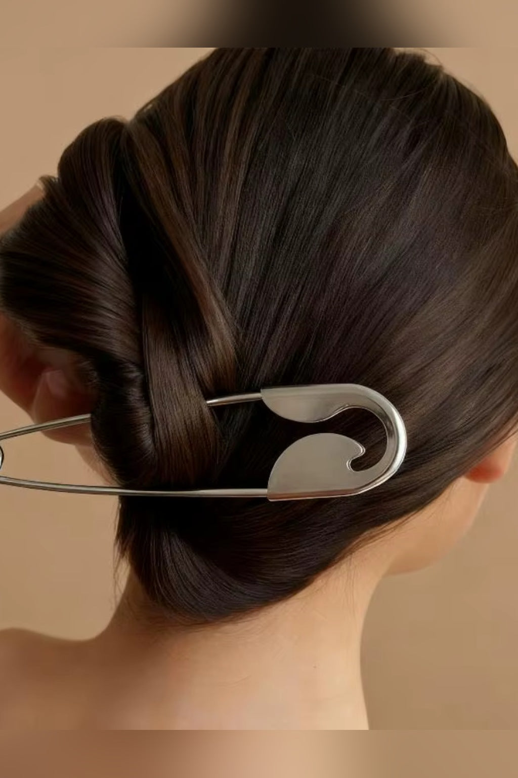 Silver safety pin hair pin holding a twisted bun