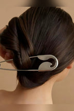 Silver safety pin hair pin holding a twisted bun