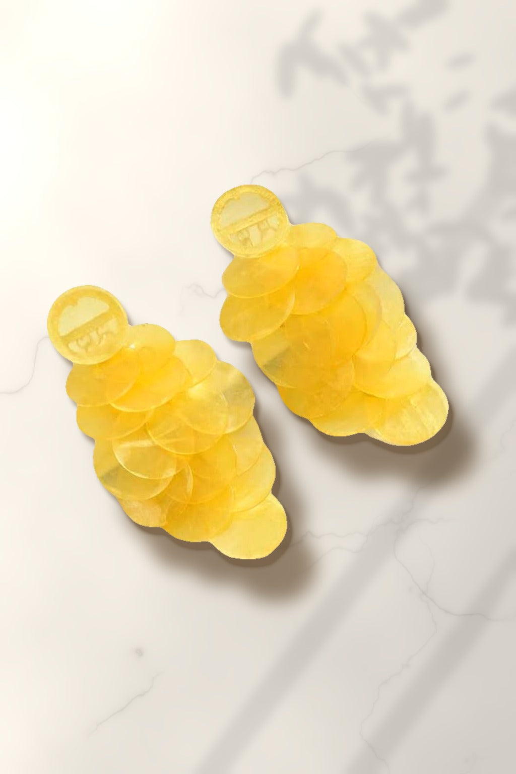 Yellow Shell Cascade Earrings – yellow capiz shell disc drop earrings on white marble in warm golden-hour sunlight